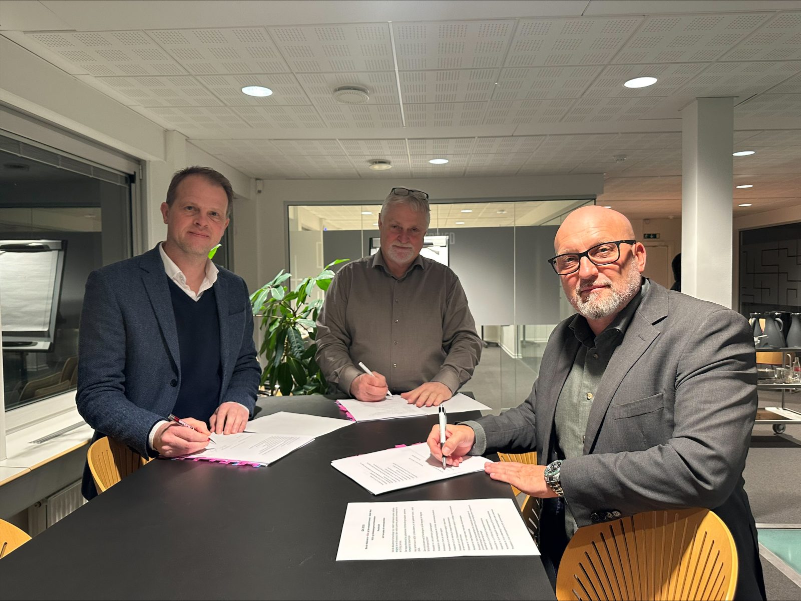 Direktør for Dansk Håndværk Morten Frihagen (tv), forbundsformand for Blik- og Rørarbejderforbundet Henrik W. Petersen (th) og faglig sekretær i Dansk Metal Michael Jensen  (i midten) underskriver den nye overenskomstaftale.